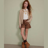 Cardigan beige lavorato con bottoni indossato da bambina con capelli rossi