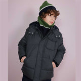 Piumino imbottito grigio scuro con cappuccio indossato da bambino con cappello e scaldacollo verde e blu